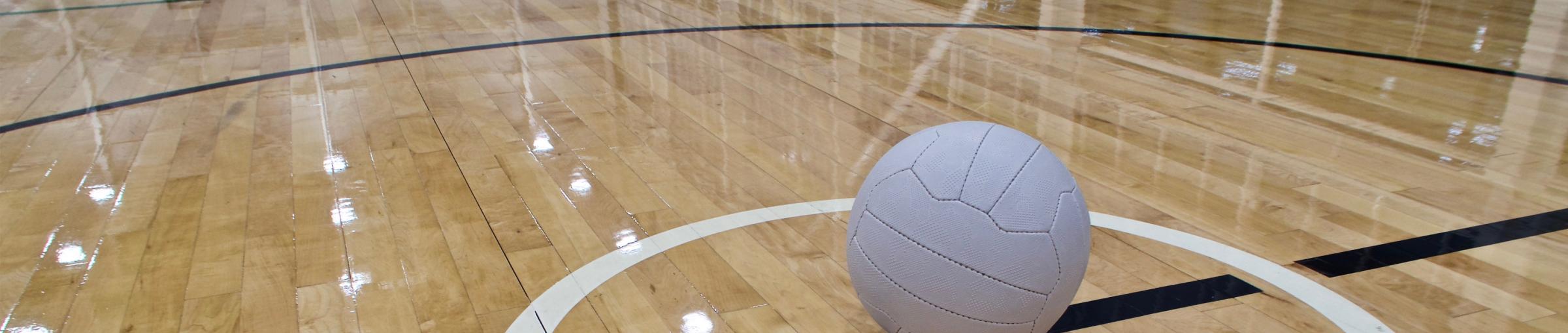 Image of netball on shiny indoor court