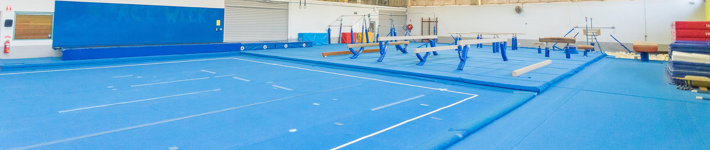 Gym room, soft floor and gymnastics equipment.