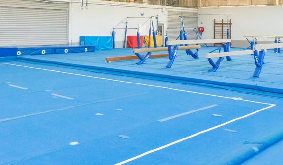 Gym room, soft floor and gymnastics equipment.