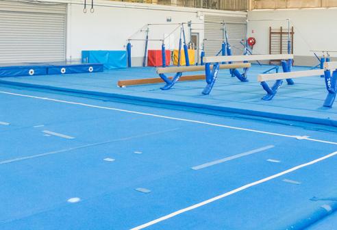 Gym room, soft floor and gymnastics equipment.